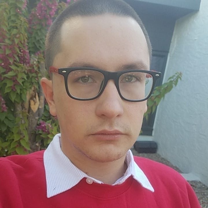 Close up of a young clean shaven man with short hair.